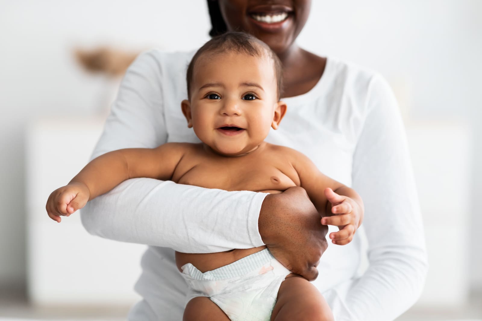 A mother holding up her happy baby after lactation support